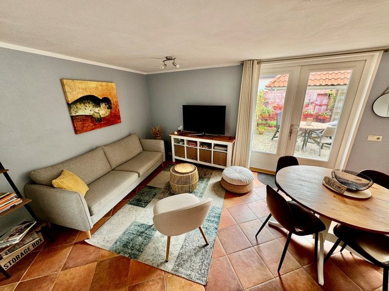 Spacious living room in Texel A, De Koog, with access to the garden and lots of natural light.