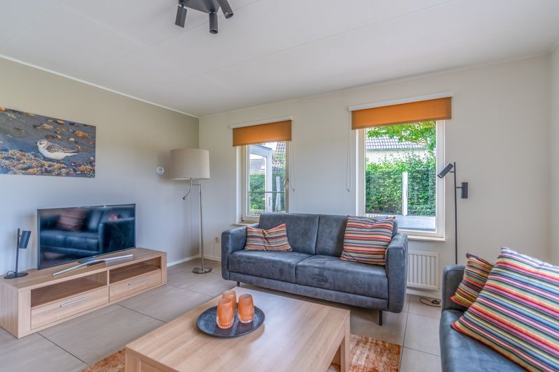 Modern seating area in Holiday home Honeysuckle 69 with sauna, De Koog, Texel, overlooking the garden.