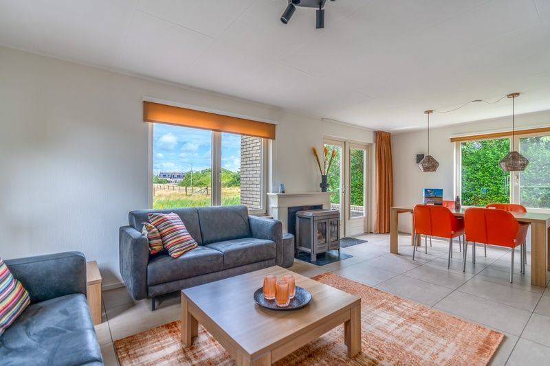 Open living space in Holiday home Honeysuckle 69 with sauna, De Koog, Texel, with access to the terrace and views of nature.