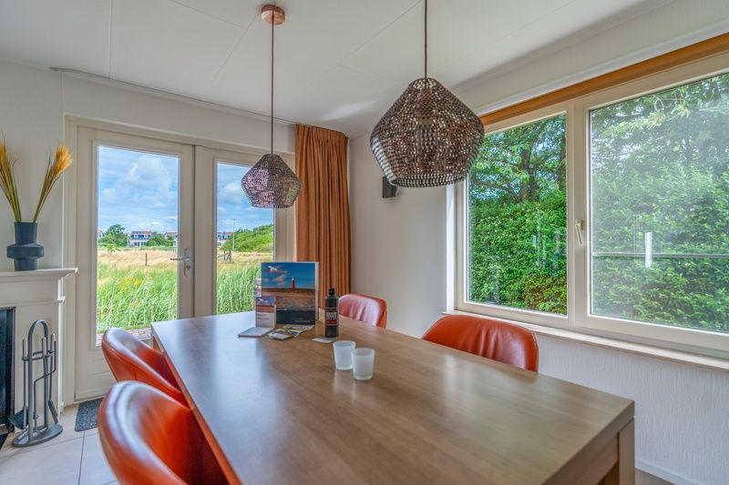 Dining area in Holiday home Honeysuckle 69 with sauna, De Koog, Texel, overlooking the surrounding countryside.