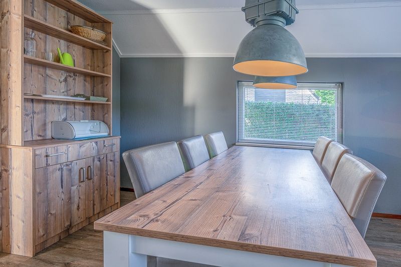 Dining room of Holiday home Honeysuckle 87 in De Koog Texel with large wooden dining table.