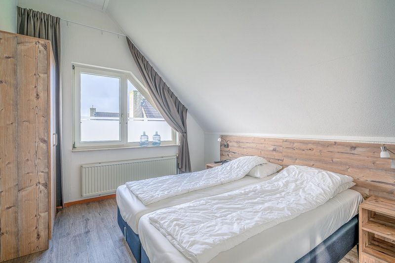 Cozy bedroom in Holiday home Honeysuckle 87, De Koog Texel with wooden accents.