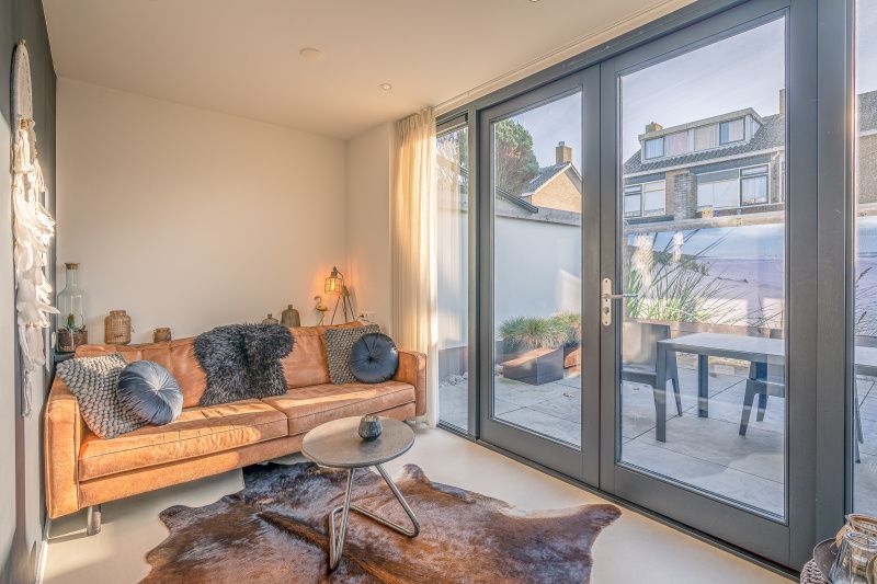 Cozy living room in vacation home Het Bospad - Brink 15, De Koog, Texel. Comfortable sofa and lots of natural light.