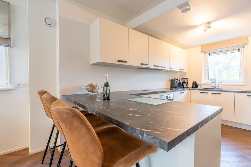 Stijlvolle eetkamer in Landhuis Het Oude Dijkje, vakantiehuis De Koog, Texel, met uitzicht op de tuin.