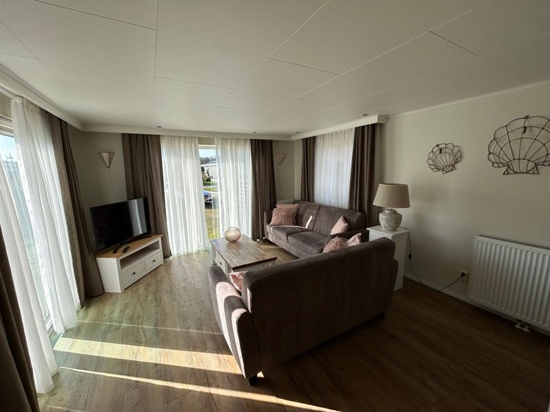 Helles Wohnzimmer im Chalet Bregkoog 213, Chaletpark Bregkoog, De Koog Texel, mit Blick auf den Garten.