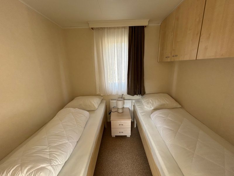 Schlafzimmer mit zwei Betten im Chalet Bregkoog 213, Chaletpark Bregkoog, De Koog Texel, fuer eine komfortable Nachtruhe.