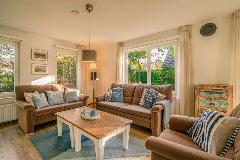 Cozy living room of Holiday home Honeysuckle 65 in De Koog, Texel, with comfortable sofas.