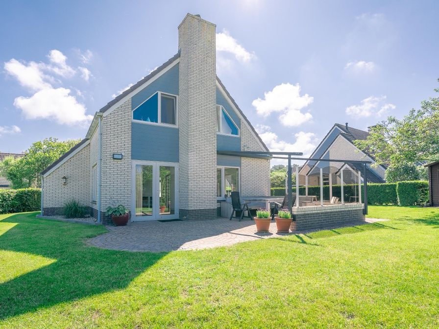 Aussenbereich des Ferienhauses Honeysuckle 75 in De Koog, Texel mit grossem Garten und Terrasse.