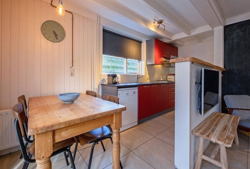 Modern kitchen in vacation home 32b Pollux, De Koog, Texel with dining area and bright red accents.