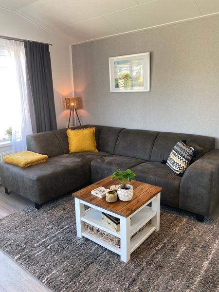 Dining room in Chalet Bregkoog 94, De Koog, Texel with wooden table and blue chairs at Chaletpark Bregkoog.