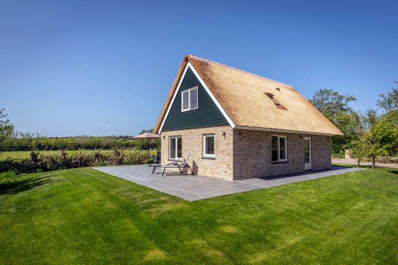 Side view of Landhuis De Wije Blick, vacation home in De Koog, Texel, with sunny garden and terrace.
