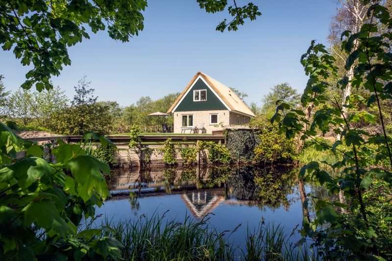 Rustic surroundings of Landhuis De Wije Blick, vacation home in De Koog, Texel, with pond and green nature.