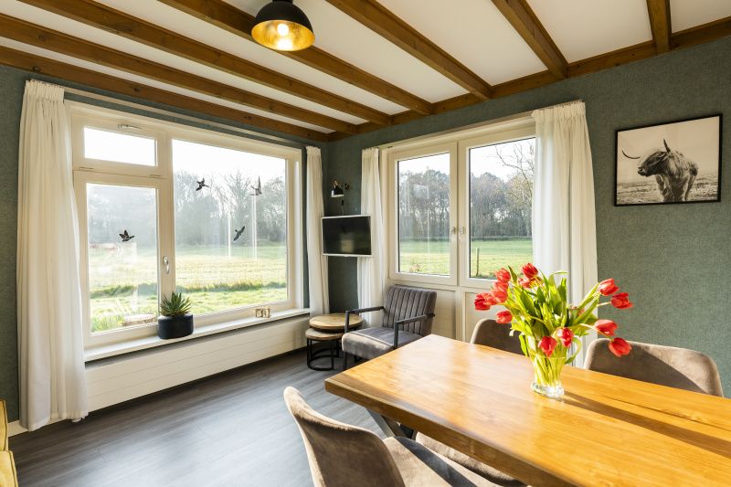 Bright dining room of De Koperwiek in De Koog Texel overlooking green fields.