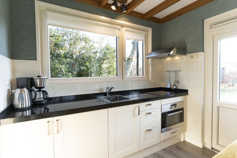 Modern kitchen of De Koperwiek in De Koog Texel with large windows.