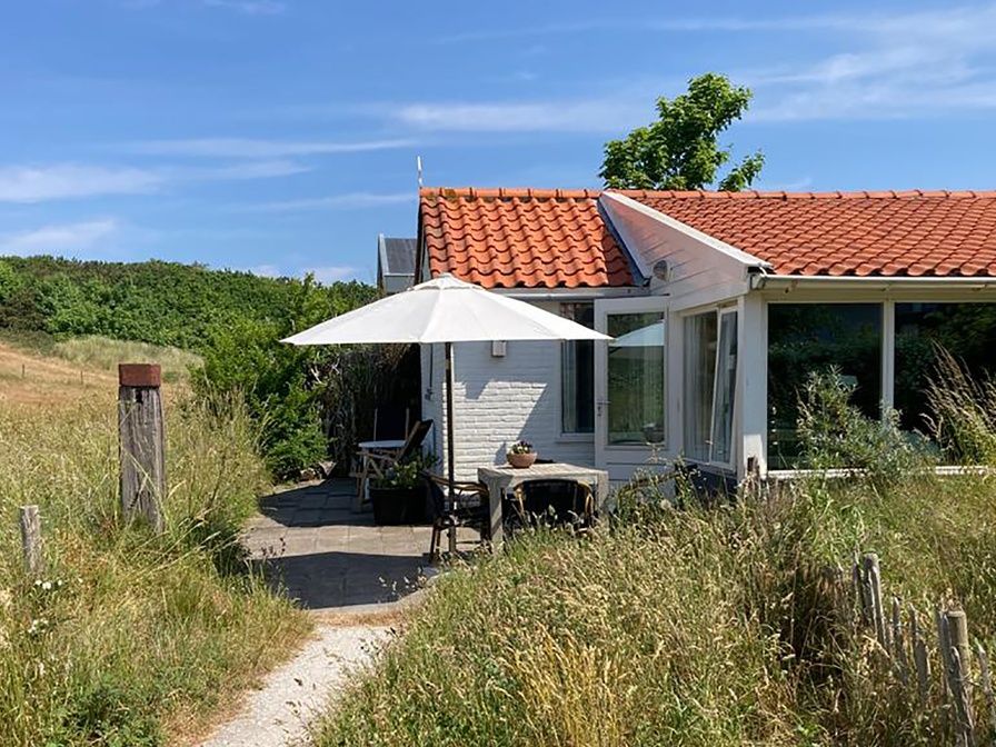 Ferienhaus Achter de Brem mit Sonnenterrasse in De Koog, Texel, umgeben von Natur.