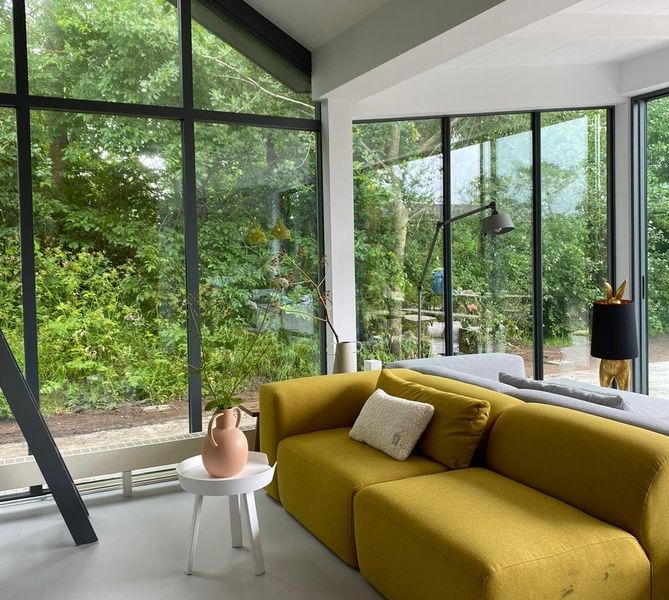 Cozy sitting area in De Koerie vacation home De Koog Texel with comfortable sofa and green surroundings.