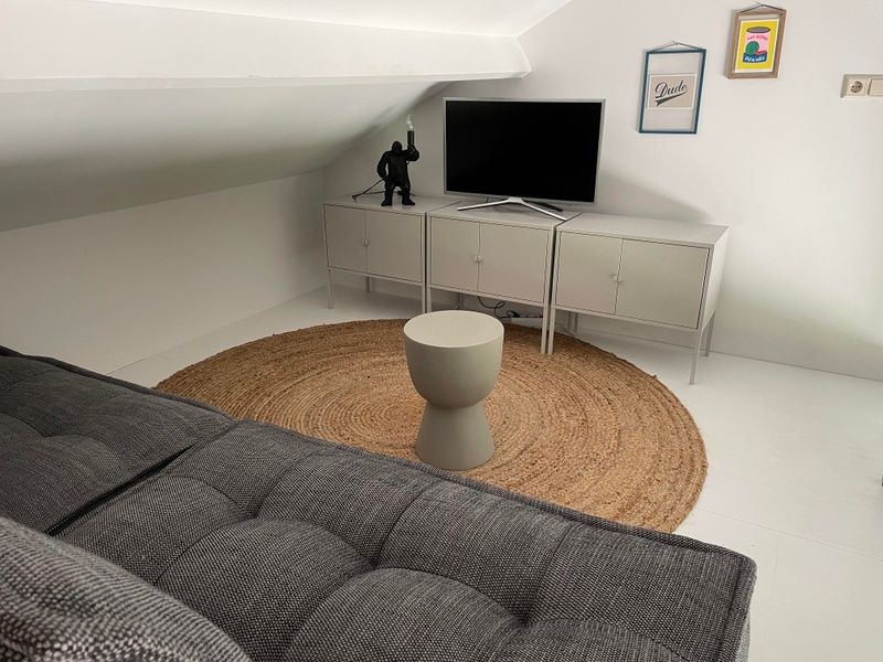 Cozy loft space in De Koerie vacation home De Koog Texel with television and comfortable seating.