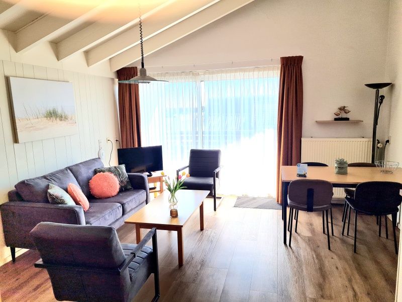 Bright living space in Motel Texel Apartment (W), De Koog, with modern furniture and terrace views.