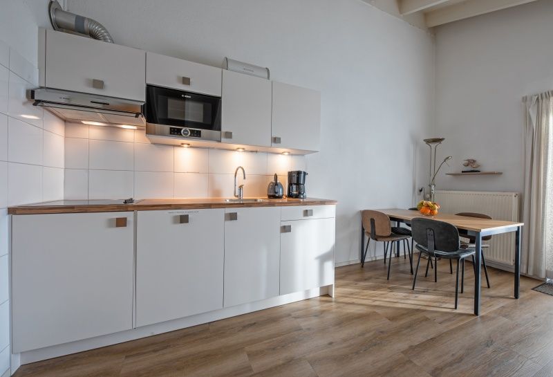 Fully equipped kitchen in Motel Texel Apartment (W), De Koog, with dining area and modern appliances.