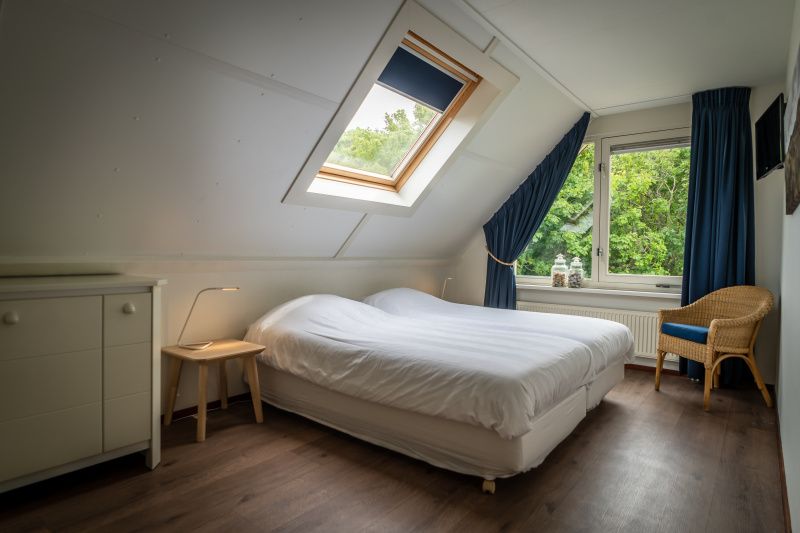 Master bedroom in Villa 6 persons with 2 bathrooms, De Koog, Texel. Spacious vacation home with a view of nature.