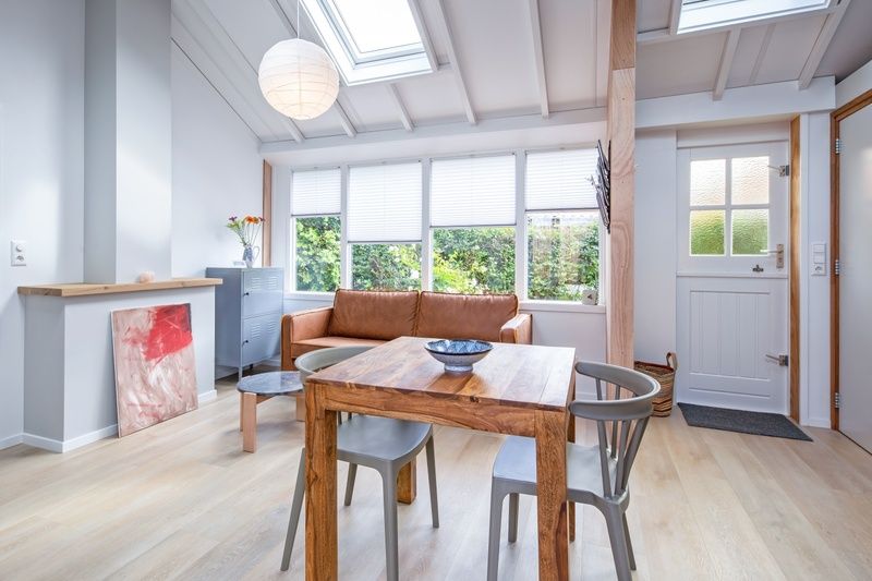 Gemuetlicher Innenbereich des Ferienhauses Pippa, De Koog, Texel, mit bequemem Sofa und Essecke.