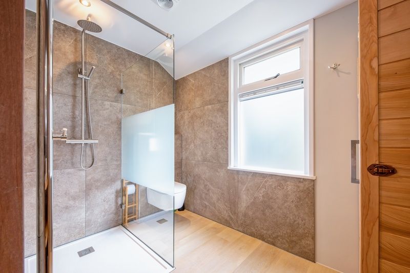 Modernes Badezimmer im Ferienhaus Pippa auf Texel, ausgestattet mit einer geraeumigen Dusche und natuerlichem Licht.