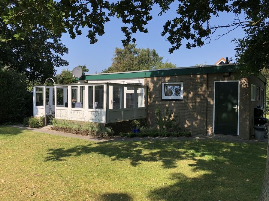 Bungalow Oud Vredelust 85 in De Koog, Texel with sunny conservatory and green surroundings.