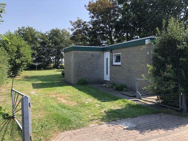 Entrance to Bungalow Oud Vredelust 85 in De Koog, Texel, surrounded by nature.
