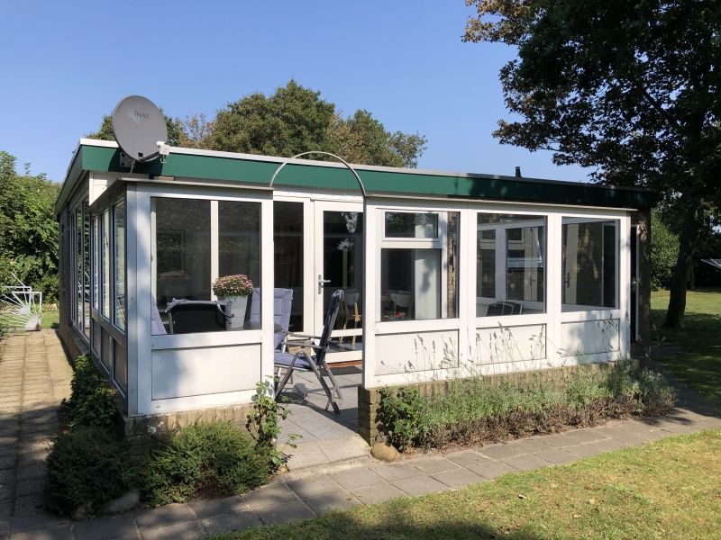 Veranda of Bungalow Oud Vredelust 85 in De Koog, Texel with garden view.
