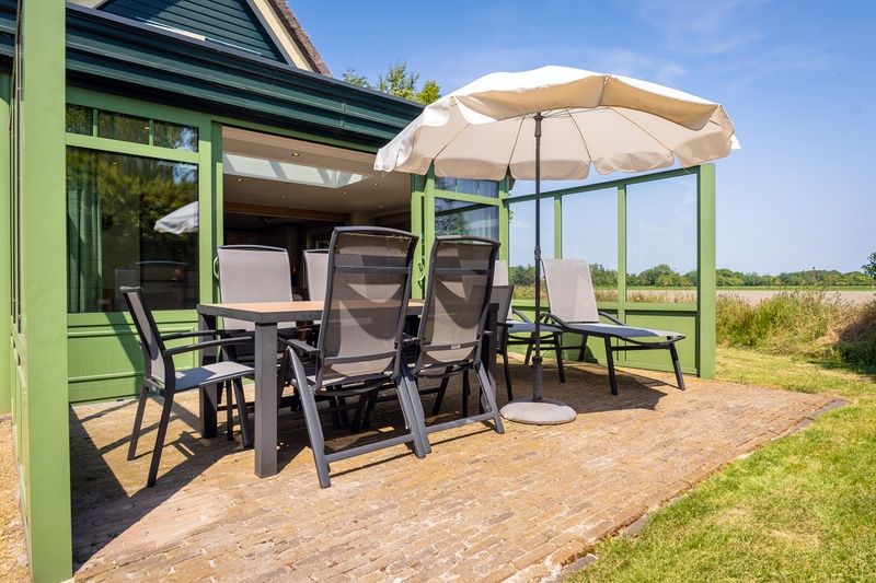 Aussenterrasse der Villa mit Wintergarten in De Koog, Texel, ideal fuer Entspannung auf den Watteninseln.