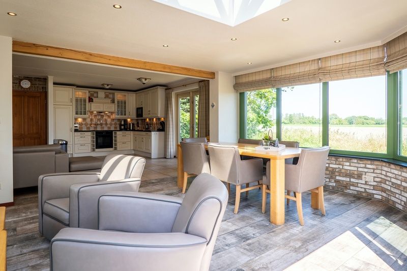 Offener Wohnraum in Villa mit Wintergarten, De Koog, Texel, mit Blick auf die gruene Umgebung.