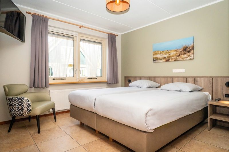 Komfortables Schlafzimmer in Villa mit Wintergarten, De Koog, Texel, mit Blick auf eine ruhige Umgebung.