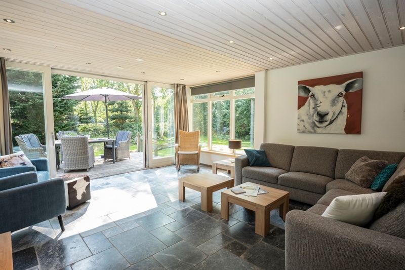 Cozy indoor area of Westenwind in De Koog, Texel with spacious sofa and access to the garden.