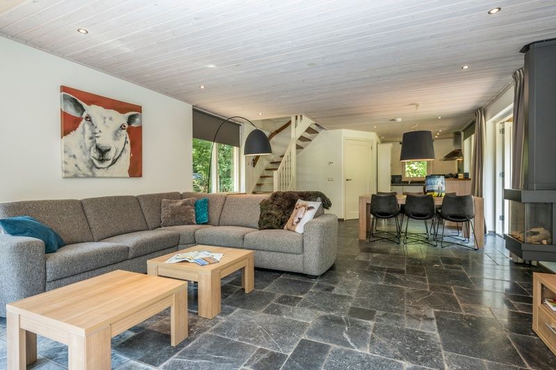 Open living room of Westenwind in De Koog, Texel with large sofa and modern kitchen.