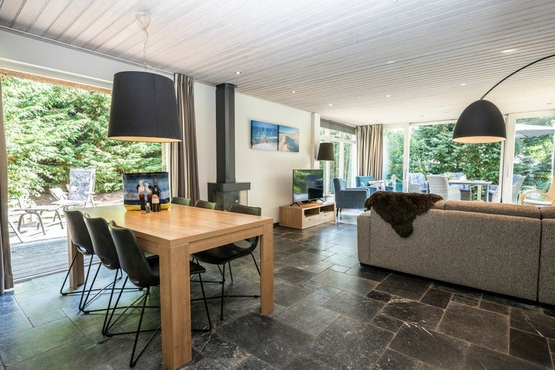 Dining room of Westenwind vacation home in De Koog, Texel with wooden table and access to terrace.