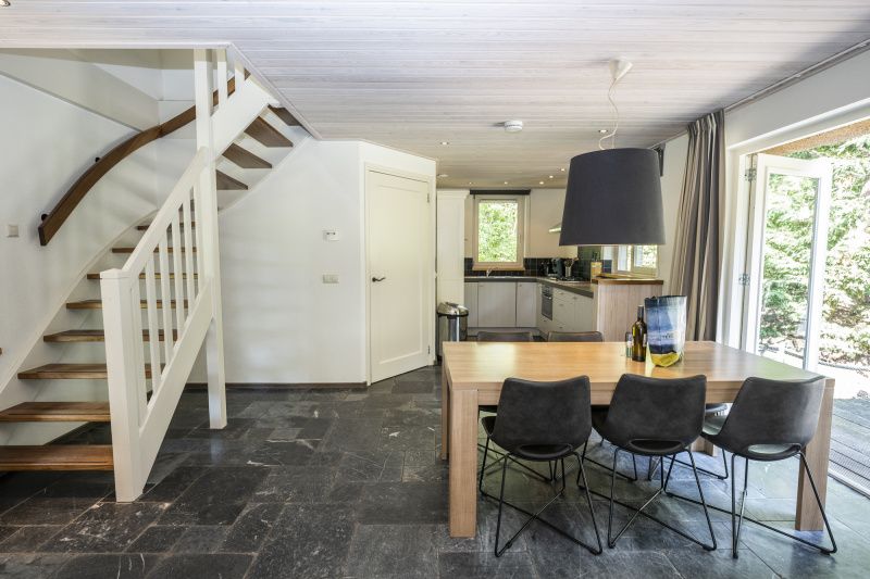 Open kitchen and stairs in Westenwind vacation home in De Koog, Texel with access to the terrace.