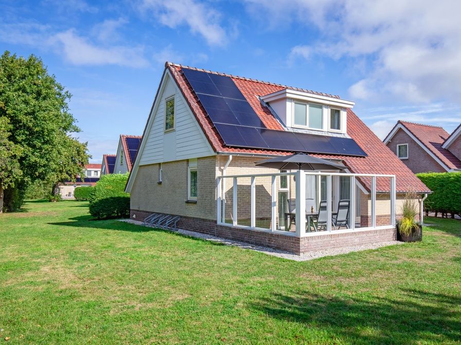 Villa 7 vacation home in De Koog Texel with spacious garden and terrace under a blue sky.