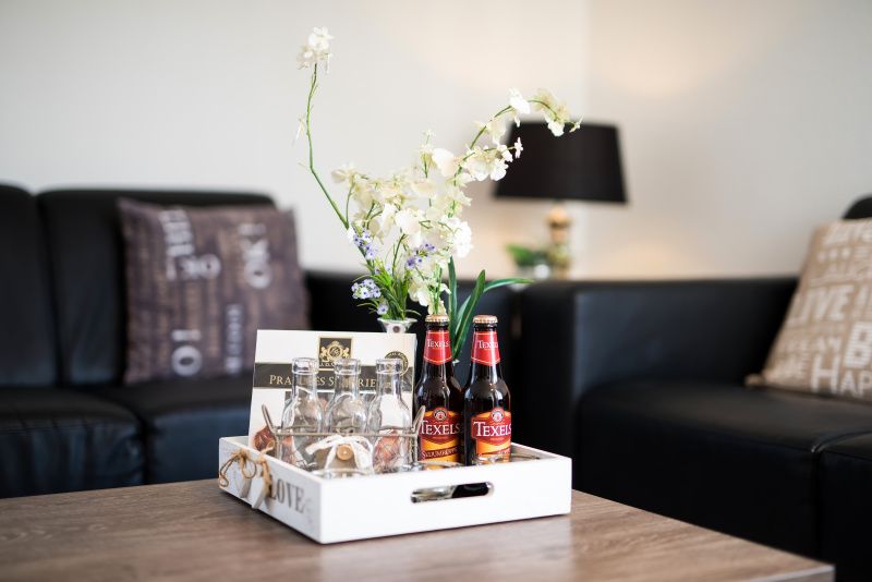 Gemuetliche Sitzecke in Villa 2, De Koog Texel, mit lokalen Texeler Bieren und stilvoller Einrichtung.