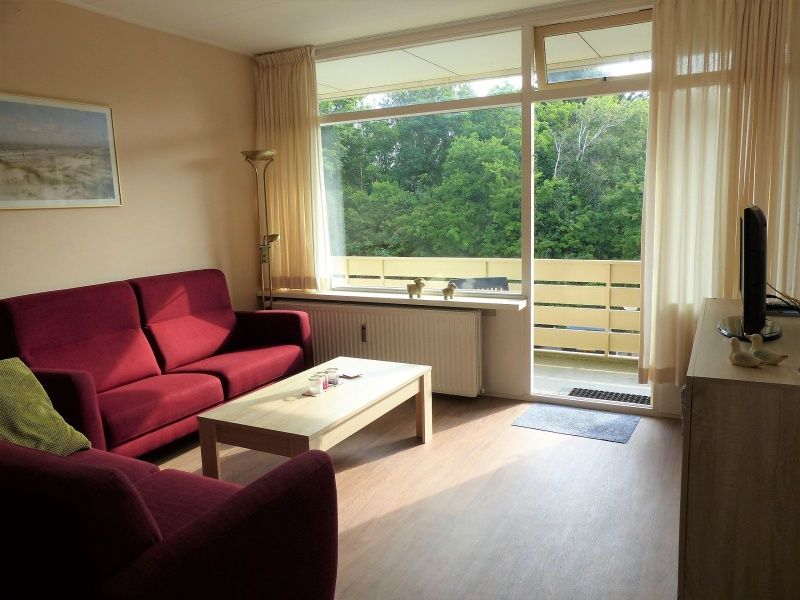 't Kerckeland - Apartment Kerckeland 86, De Koog, Texel: sunny living room with large windows and views of the green landscape.