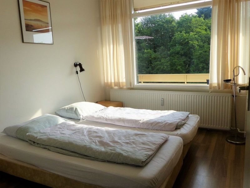 't Kerckeland - Apartment Kerckeland 86, De Koog, Texel: bright bedroom with two single beds and a beautiful view of nature.