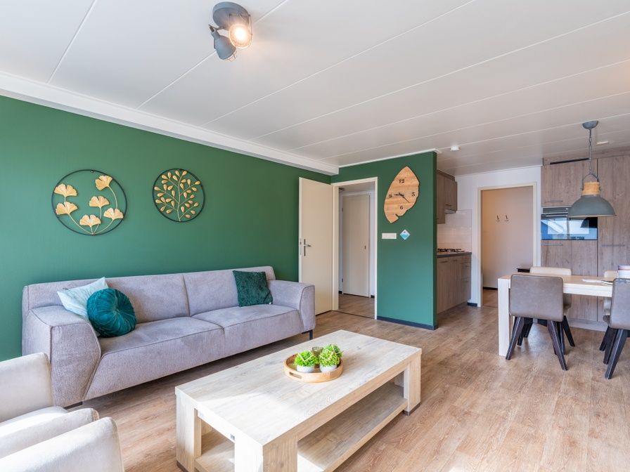 Stilvolles Wohnzimmer des Appartements Anna 218 in De Koog, Texel, mit gruenen Akzenten und gemuetlicher Sitzecke.