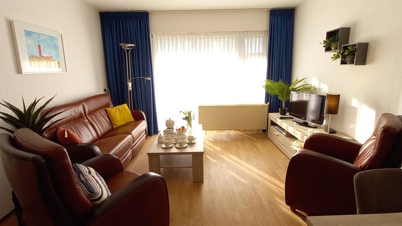 Geraeumiges und helles Wohnzimmer in De Pelikaan Apartments, De Koog, Texel mit modernen Moebeln und gemuetlicher Atmosphaere.