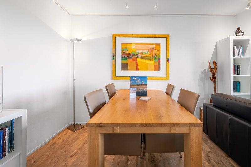 Dining area of Apartment Juliana 112 Zeezicht in De Koog, Texel with modern art on the wall.