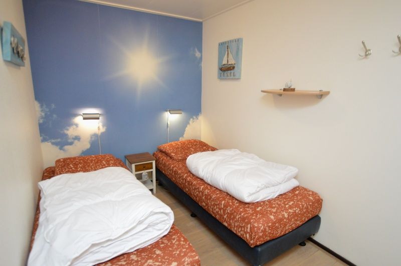 Bedroom with two single beds in Apartments Anna - Sun, De Koog, Texel, offers comfort and tranquility.