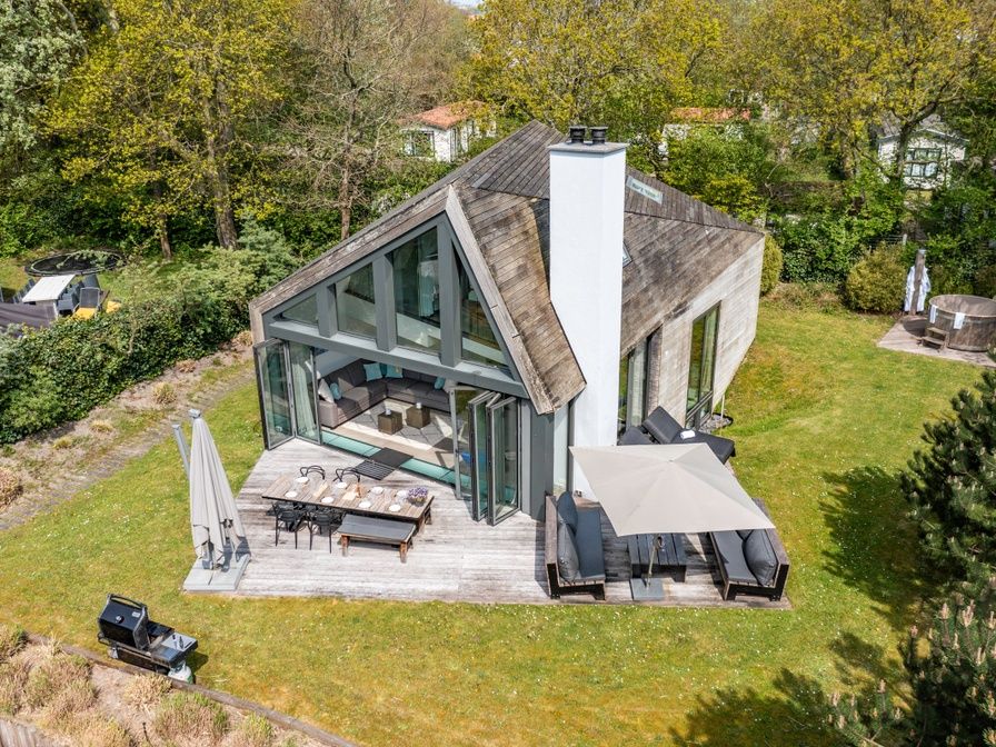 Relax on the terrace of Duynzoom Villa 5, a luxury vacation home in De Koog, Texel, surrounded by green nature.