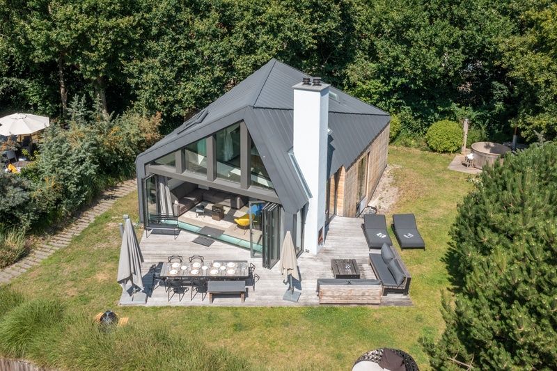 Enjoy the serene garden surrounding Duynzoom Villa 5, a vacation home in De Koog, Texel, perfect for a relaxing stay.