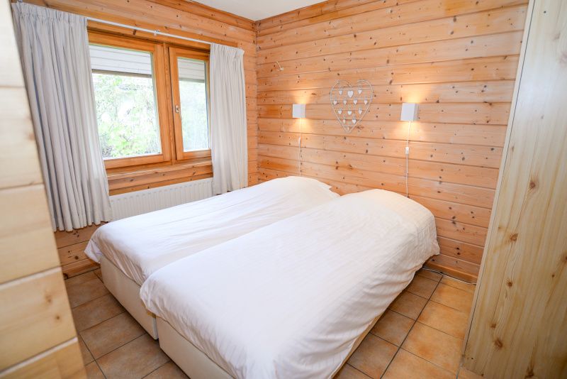 Schlafzimmer mit zwei Betten und Holzwaenden im Vakantiepark Het Oude Dijkje, De Koog, Texel, bietet Ruhe und Komfort.