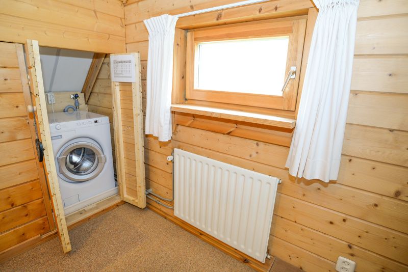 Praktischer Waschraum mit Waschmaschine im Vakantiepark Het Oude Dijkje, De Koog, Texel, fuer zusaetzlichen Komfort waehrend Ihres Aufenthalts.