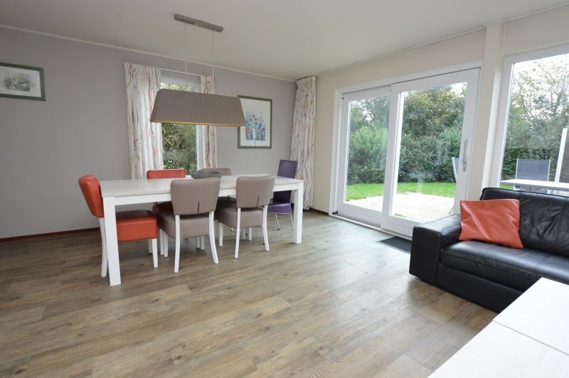Dining room in Holiday home Stappeland 76, De Koog, Texel overlooking green garden.