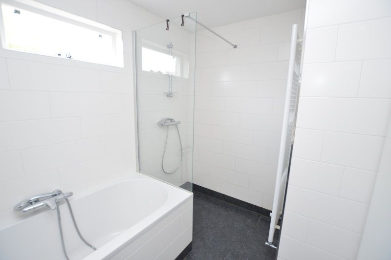Stylish bathroom with bath and shower in Holiday home Stappeland 76, De Koog, Texel.